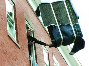 Greg Keane guiding a piano on a crane